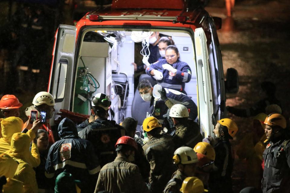 巴西救難人員7日將公寓倒塌現場救出的一名傷者送醫。路透社