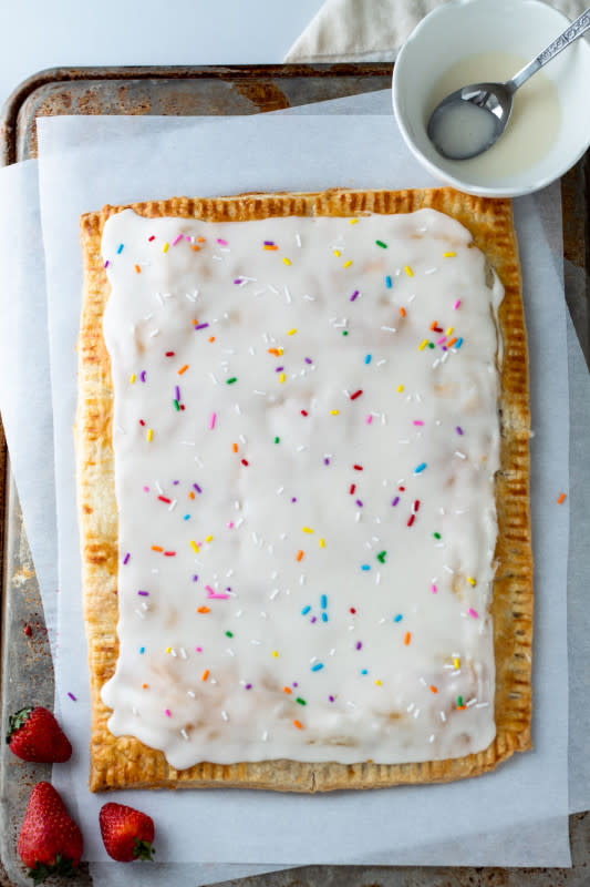 <p>Parsley and Icing</p><p>This giant strawberry pop tart has a tender, super delicious crust, is bursting with strawberry jam and topped with the easiest, most delicious icing and some fun, rainbow sprinkles!</p><p><strong>Get the recipe: <a href="https://parsleyandicing.com/giant-strawberry-pop-tart/" rel="nofollow noopener" target="_blank" data-ylk="slk:Giant Strawberry Pop Tart;elm:context_link;itc:0;sec:content-canvas" class="link rapid-noclick-resp"><em>Giant Strawberry Pop Tart</em></a></strong></p>