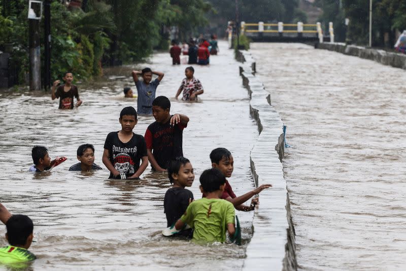 Niños jugando en las aguas de la inundación en la residencia Pondok Maharta, Tangerang, cerca de Yakarta, Indonesia, 25 de febrero de 2020 en esta foto tomada por Antara Foto