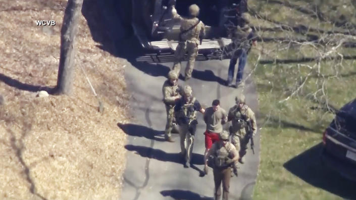 Jack Teixeira es detenido por agentes tácticos armados el 13 de abril de 2023 en Dighton, Massachusetts. (WCVB-TV vía AP)