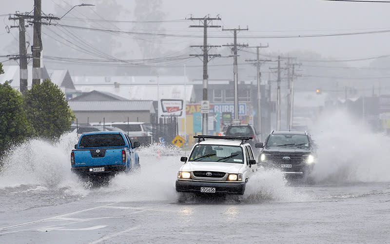 Cars move through flooded roads in northern New Zealand