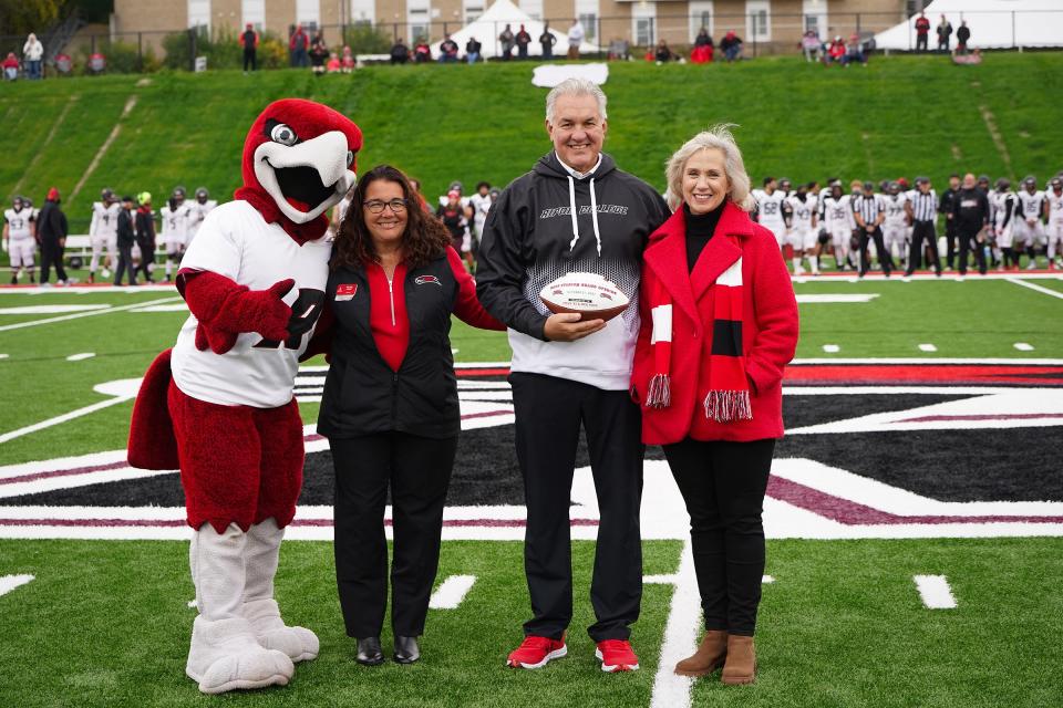 Ripon College’s Rally the Red Hawk is pictured with, from left, Ripon College President Victoria N. Folse, Steve Hopp, class of 1983 and Meg Hopp during the grand opening of the new Hopp Stadium.
