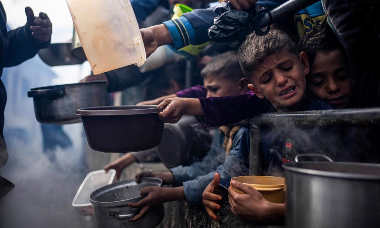 <span>Palestinian children line up for a meal in Rafah, Gaza Strip.</span><span>Photograph: Fatima Shbair/AP</span>