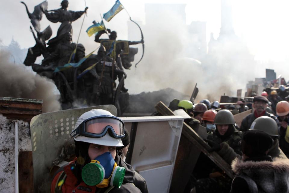 Anti-government protesters protect themselves with shields during clashes with riot police in Kiev's Independence Square, the epicenter of the country's current unrest, Kiev, Ukraine, Wednesday, Feb. 19, 2014. The deadly clashes in Ukraine’s capital have drawn sharp reactions from Washington, generated talk of possible European Union sanctions and led to a Kremlin statement blaming Europe and the West. (AP Photo/Sergei Chuzavkov)