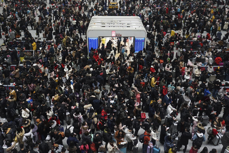 In this Sunday, Feb. 10, 2019, file photo, Chinese travelers wait for their trains at a railway station in Hangzhou in east China's Zhejiang province. Millions of Chinese are start returning to work after spending a weeklong Lunar New Year holiday with families in their hometown. (Chinatopix via AP, File)