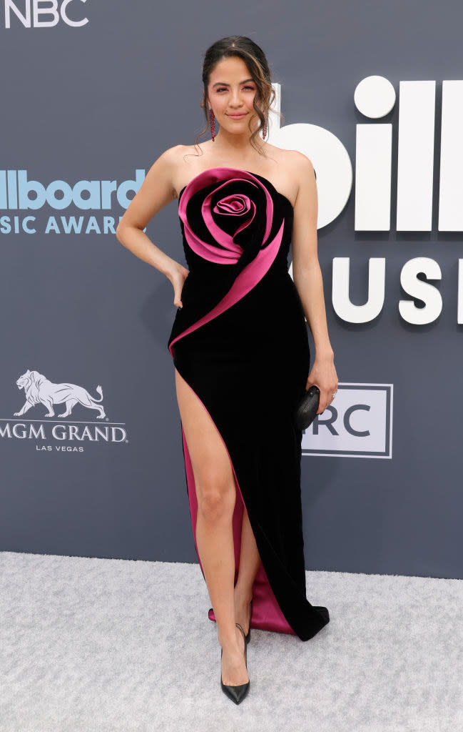 Erin Lim wearing a black and magenta gown with detailing made to look like a rose at the front while on the BBMAs red carpet.