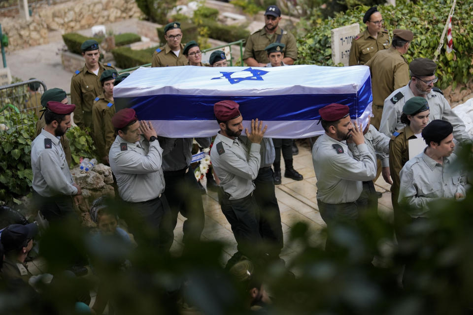 Israeli soldiers carry the flag-covered coffin of Maj. Tal Cohen during his funeral at the Givat Shaul cemetery in Jerusalem on Tuesday, Oct. 10, 2023. The latest Israel-Palestinian war reverberated around the world Tuesday, as foreign governments tried to determine how many of their citizens were dead, missing or in need of medical help or flights home. (AP Photo/Francisco Seco)