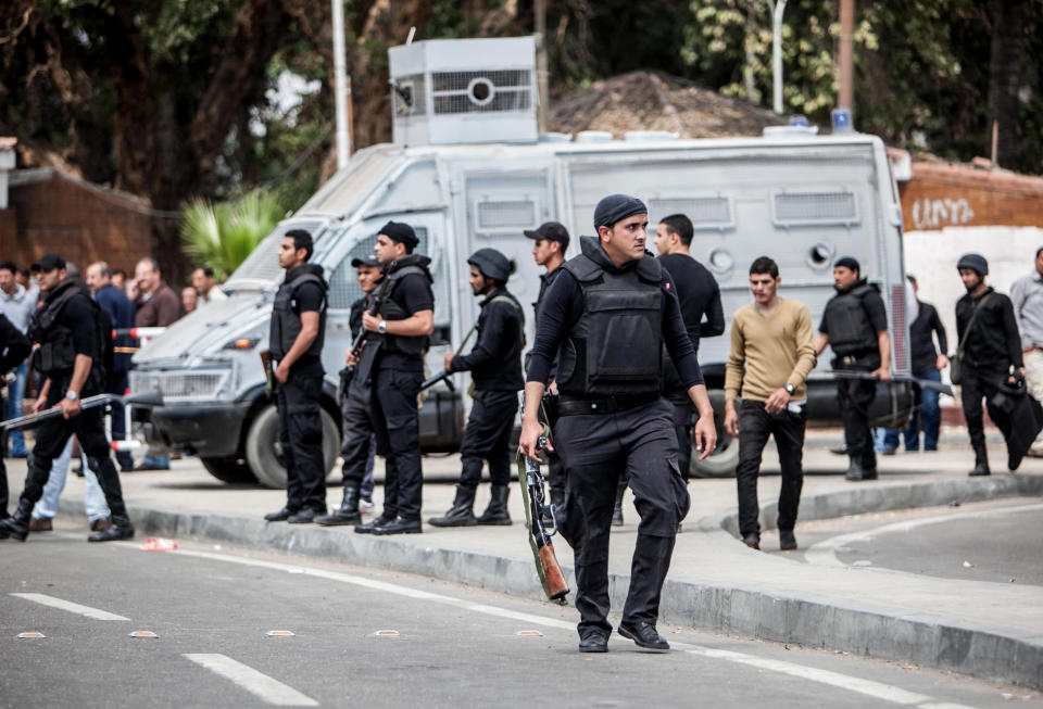 Egyptian security forces stand guard at the scene after multiple explosions hit the area outside the main campus of Cairo University, killing at least two, in Giza, Egypt, Wednesday, April 2, 2014. The bombings targeted riot police routinely deployed at the location in anticipation of near-daily protests by students who support ousted Islamist President Mohammed Morsi and his Muslim Brotherhood group. (AP Photo/Amru Taha)