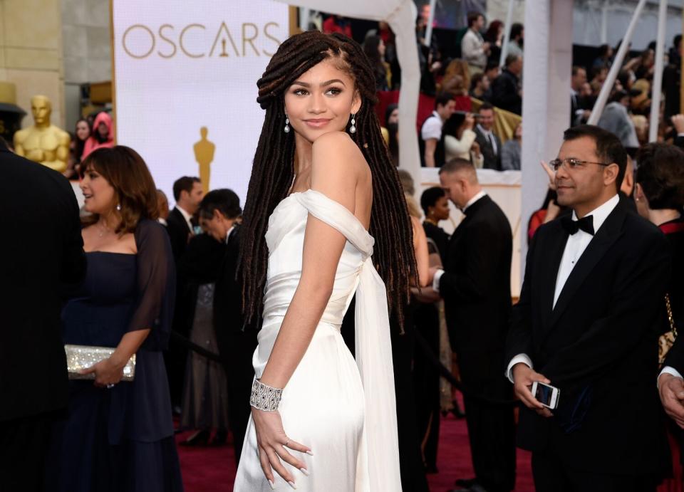 A woman shows off her white gown on the red carpet at the 87th Academy Awards in Hollywood in 2015.