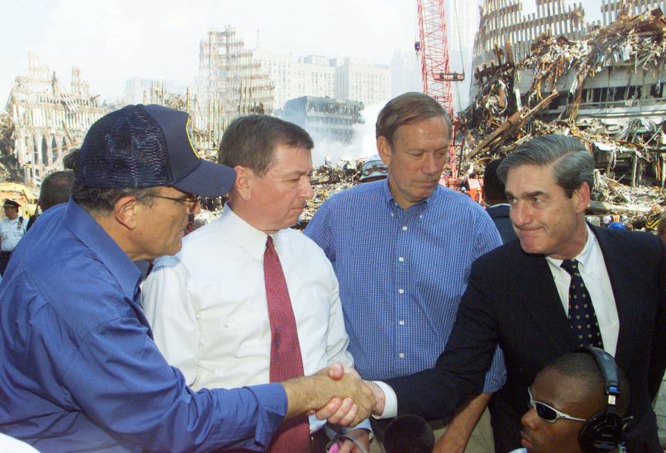 FBI Director Robert Mueller, right, shakes hands with New York Mayor Rudolph Giuliani, left, at ground zero in New York on Friday, Sept. 21, 2001.