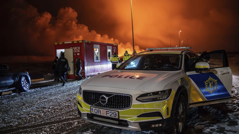The police vehicle is parked at the entrance of the road to Grindavík with the volcanic eruption in the background. The eruption started Monday night on Iceland's Reykjanes peninsula, turning the sky orange and prompting the country's civil defense to be on high alert. - Marco Di Marco/AP