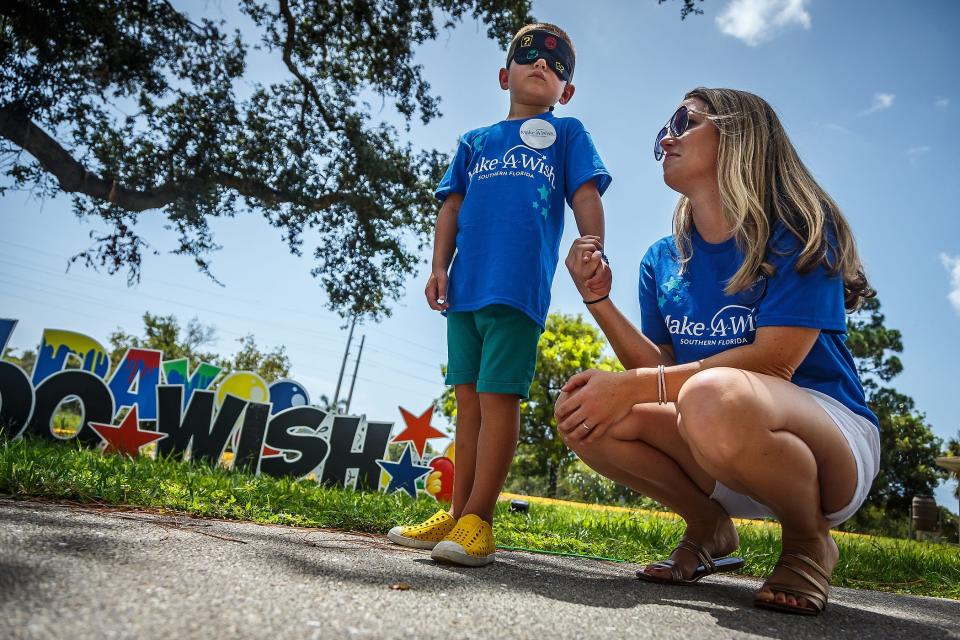 Charlie Maloney, blindfolded, waits with his mother Katie Newton, both of Delray Beach, during a Make-A-Wish event at Caloosa Park in Boynton Beach on July 21. Charlie, who was diagnosed with acute lymphoblastic leukemia in October 2021, received a Mario Bros. themed golf cart.
(Credit: THOMAS CORDY/THE PALM BEACH POST)