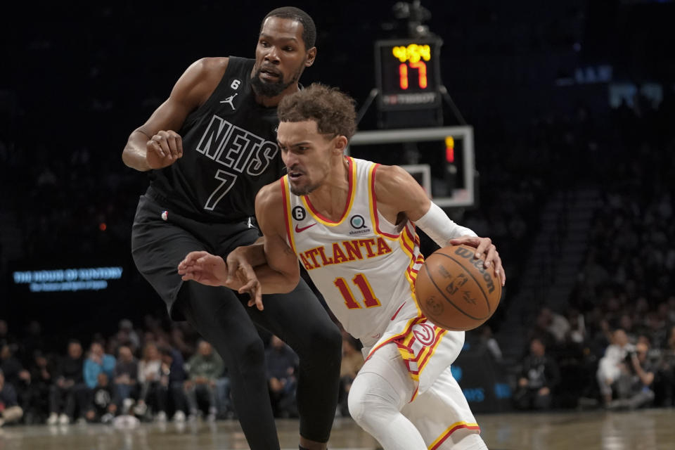 Atlanta Hawks guard Trae Young (11) drives against Brooklyn Nets forward Kevin Durant (7) during the first half of an NBA basketball game Friday, Dec. 9, 2022, in New York. (AP Photo/Mary Altaffer)