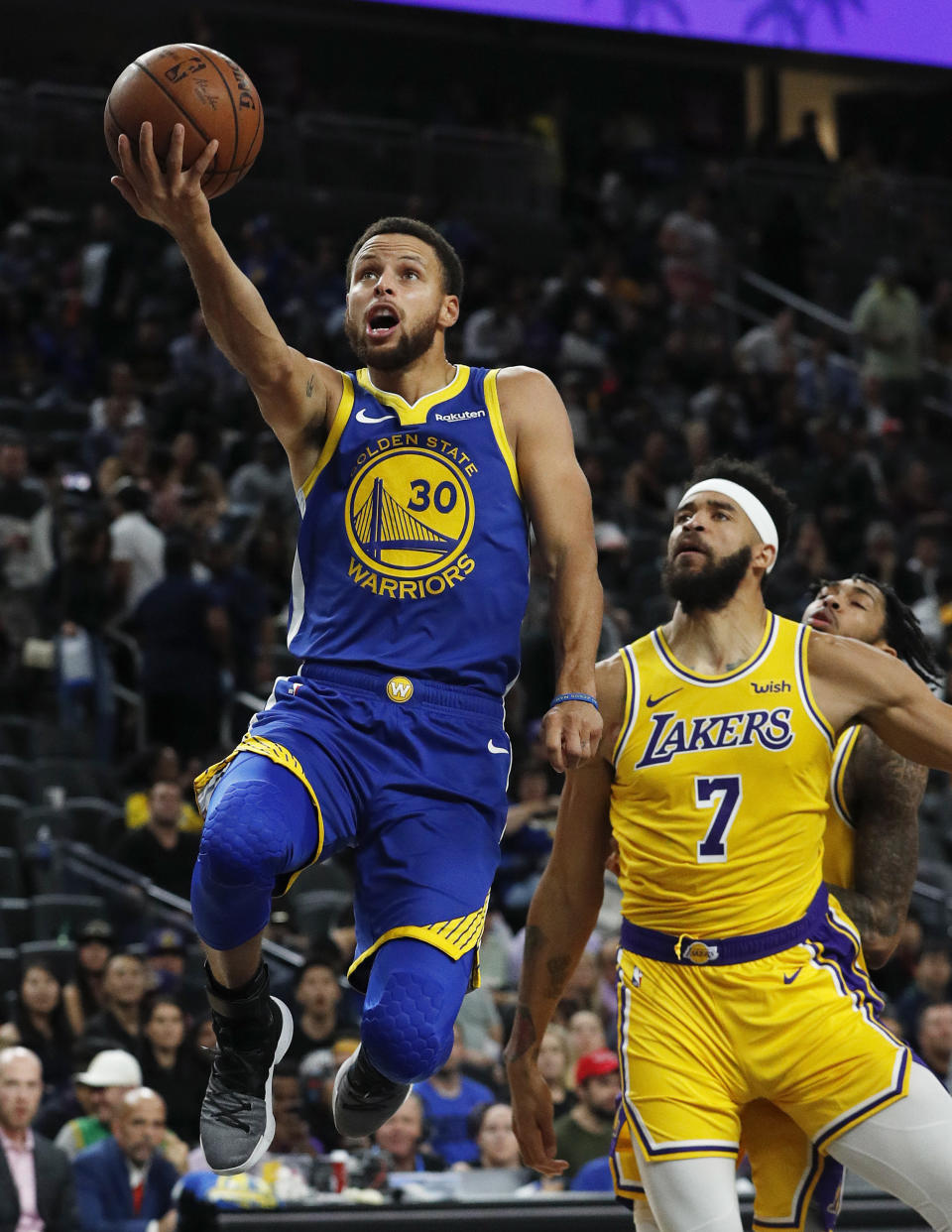 FILE - In this Oct. 10, 2018, file photo, Golden State Warriors guard Stephen Curry shoots next to Los Angeles Lakers center JaVale McGee during the second half of an NBA preseason basketball game, in Las Vegas. NBA Commissioner Adam Silver will be at Oracle Arena on Tuesday night, handing the Golden State Warriors what will be their third set of championship rings from the last four seasons. A banner will be displayed. Highlights will be shown. And then the Warriors will have to start all over again.(AP Photo/John Locher, File)