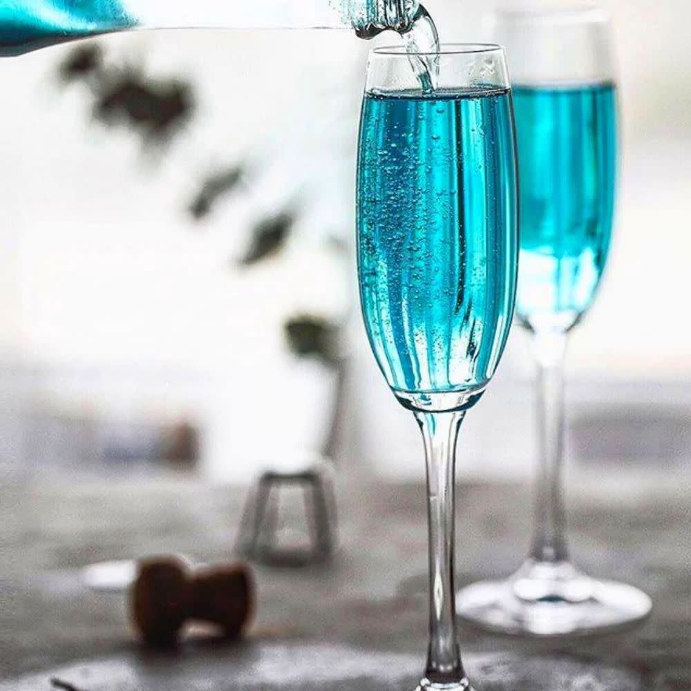 Two glasses, one full, one being topped up with blue bubbly wine.