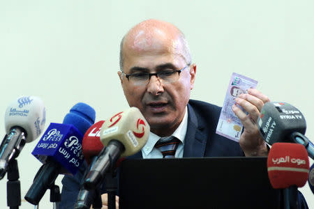Central Bank of Syria governor Duraid Durgham speaks during a news conference as he holds the new Syrian 2,000-pound banknote that went into circulation on Sunday, in this handout picture provided by SANA on July 2, 2017, Syria. SANA/Handout via REUTERS