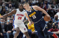 Denver Nuggets center Nikola Jokic, front, drives to the rim past Detroit Pistons center Isaiah Stewart in the first half of an NBA basketball game Sunday, Jan. 23, 2022, in Denver. (AP Photo/David Zalubowski)