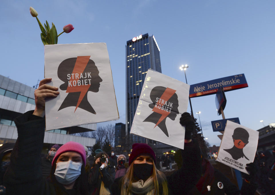 People take part in a protest on International Women's Day in Warsaw, Poland, Monday March 8, 2021. Women’s rights activists in Poland marked International Women’s Day on Monday caught between reasons to celebrate and a heavy sense that they are facing a long battle ahead. This year’s Women’s Day, which is being marked with protests, comes after a near total ban on abortion took effect in January in the historically Roman Catholic country, a step that had long been been sought by the conservative ruling party, Law and Justice. (AP Photo/Czarek Sokolowski)