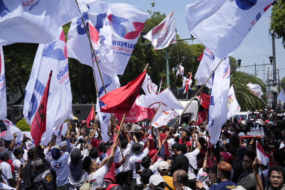 Supporters of presidential candidate Ganjar Pranowo wave political parties' flags as they wait for Pranowo's arrival to officially register his candidacy to run in the 2024 election, at the General Election Commission building in Jakarta, Indonesia, Thursday, Oct. 19, 2023. The world's third-largest democracy is set to vote in simultaneously legislative and presidential elections on Feb. 14, 2024. (AP Photo/Achmad Ibrahim)