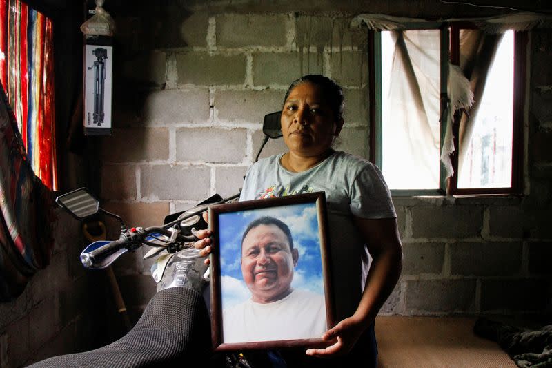 Marilú Sanchez sostiene una fotografía de su esposo asesinado Gustavo Sánchez, un periodista que recibió disparos de asaltantes mientras viajaba en motocicleta con su hijo, en su casa en Morro de Mazatán, en el estado Oaxaca, México, October 18, 2022. REUTERS/Jorge Luis Plata