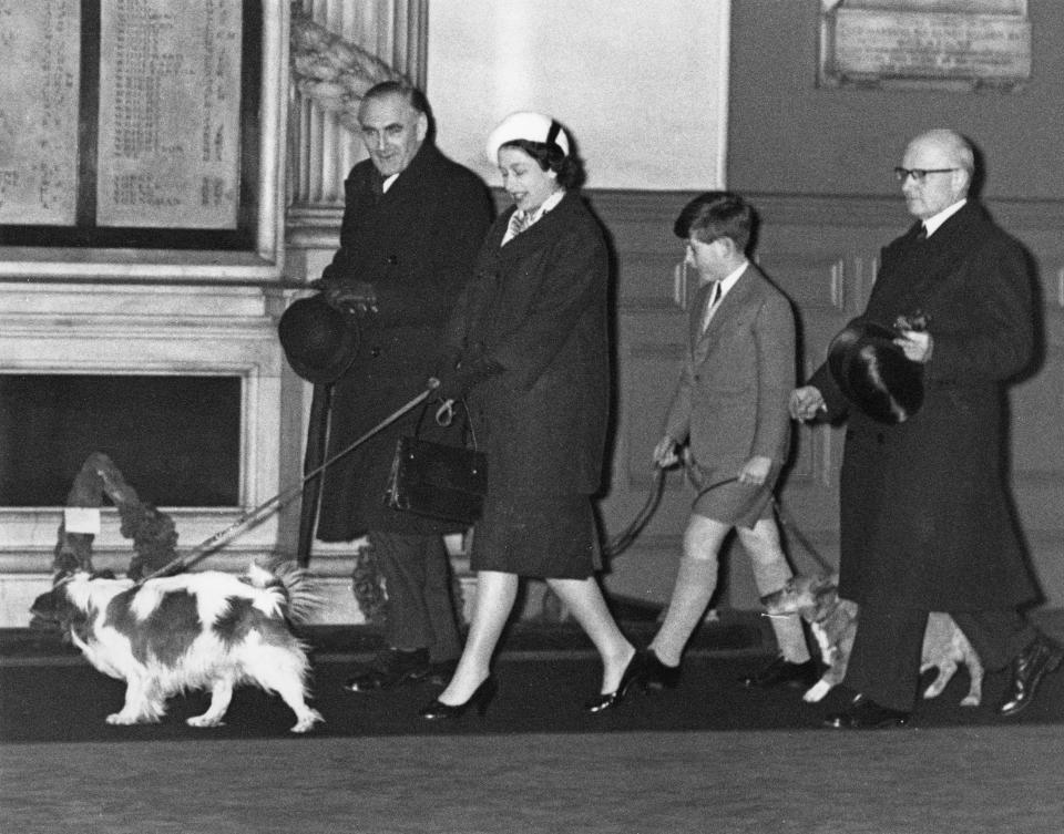 Queen Elizabeth II and Prince Charles walk through Liverpool Street Station in London with their dogs, having returned by train from Sandringham after the Christmas holidays, 18th January 1960. The Queen is expecting the birth of her son Prince Andrew in one month's time. (Photo by Derek Berwin/Fox Photos/Getty Images)