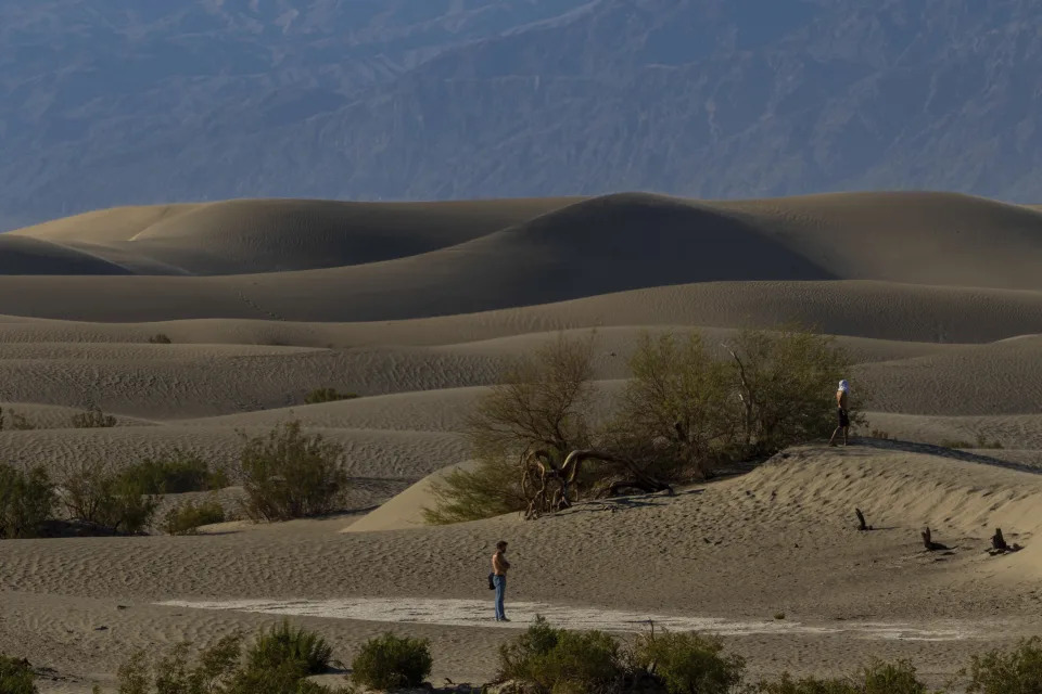 A man explores the Mesquite Flat Sand Dunes on Tuesday, July 11, 2023, in Death Valley National Park, Calif. July is the hottest month at the park with an average high of 116 degrees (46.5 Celsius). (AP Photo/Ty ONeil)