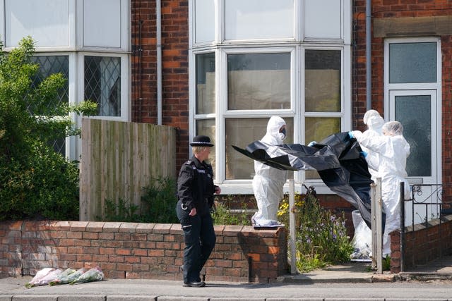 Police forensic officers work at the scene