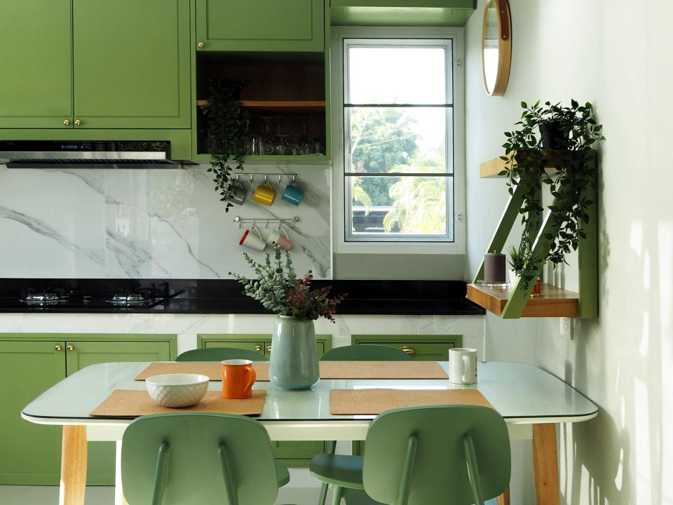 Kitchen with green chairs and cabinets