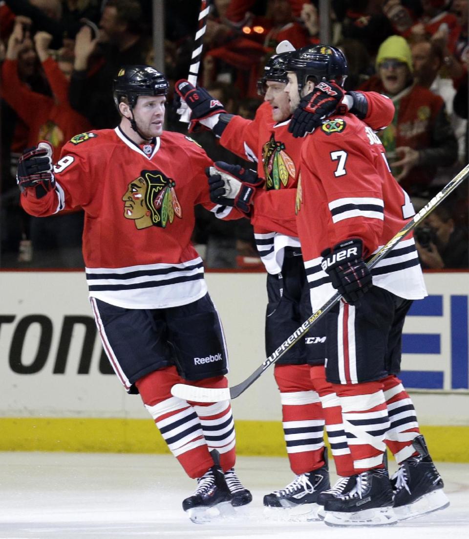 Chicago Blackhawks' Bryan Bickell, left, celebrates with teammate Marian Hossa, center, and Brent Seabrook (7) after scoring a goal against the St. Louis Blues during the first period in Game 6 of a first-round NHL hockey playoff series in Chicago, Sunday, April 27, 2014. (AP Photo/Nam Y. Huh)