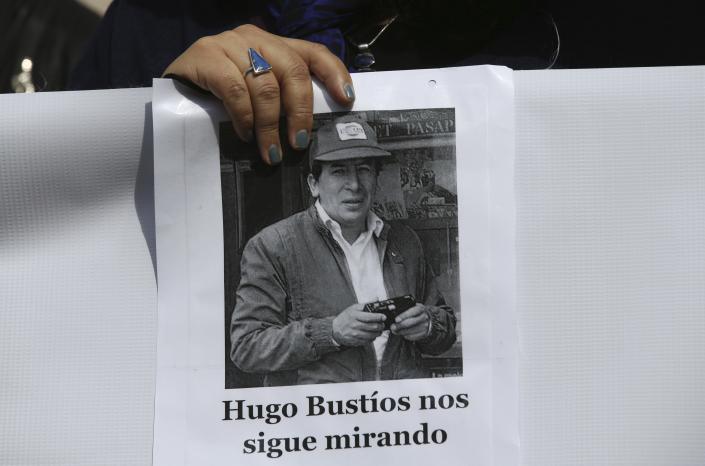 A protester held a photo of Hugo Bustíos, wearing a baseball cap, holding what appeared to be a disposable camera, along with a Spanish text that translates as follows: 