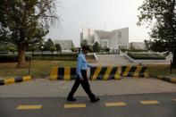 FILE PHOTO: A policeman walks past the Supreme Court building in Islamabad