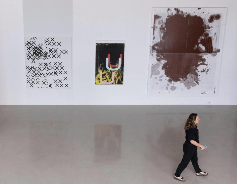 Jessica Katz, directora de Christie's Miami, camina junto a obras que fueron propiedad de Rosa de la Cruz en De la Cruz Collection, el lunes 8 de abril de 2024, en Miami, Florida. La obra de Wade Guyton (centro) se vendió en una subasta de Christie's el 14 de mayo de 2024 por $850,000, comisiones no incluidas. La obra de Christopher Wool (derecha) se vendió por $970,000, comisiones no incluidas.