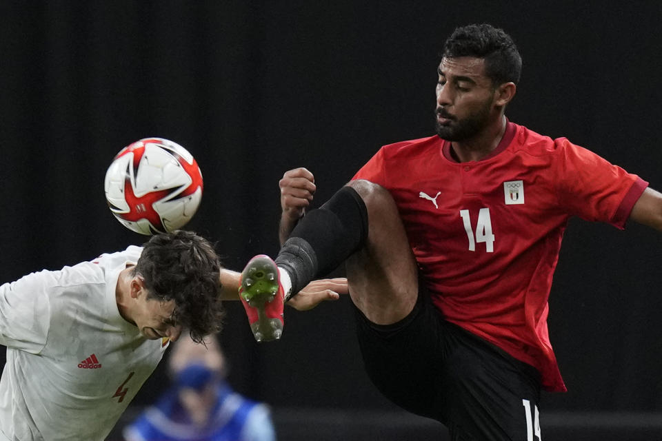 El español Pau Torres (izquierda) y el egipcio Ahmed Rayan pugnan por el balón en partido por el fútbol masculino de los Juegos Olímpicos de Tokio, el jueves 22 de julio de 2021, en Sapporo. (AP Foto/SIlvia Izquierdo)