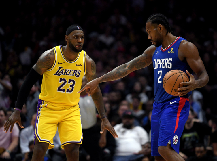 Kawhi Leonard of the Clippers controls the ball in front of Lakers forward LeBron James.