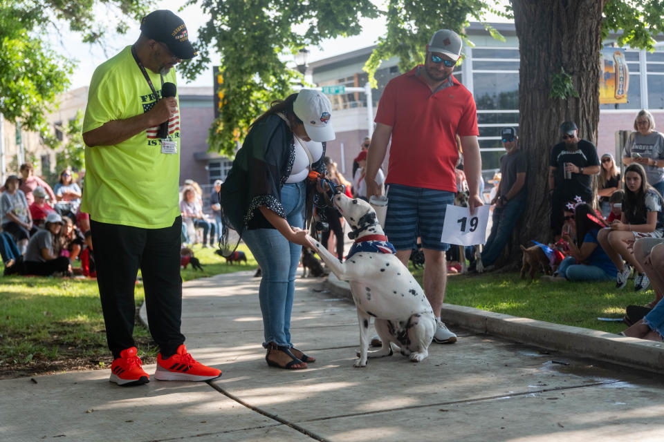 Amy Solis gets her dog Luka to shake hands at Center City's 3rd annual Patriotic Pet Parade Saturday at the Amarillo Community Market in downtown Amarillo.