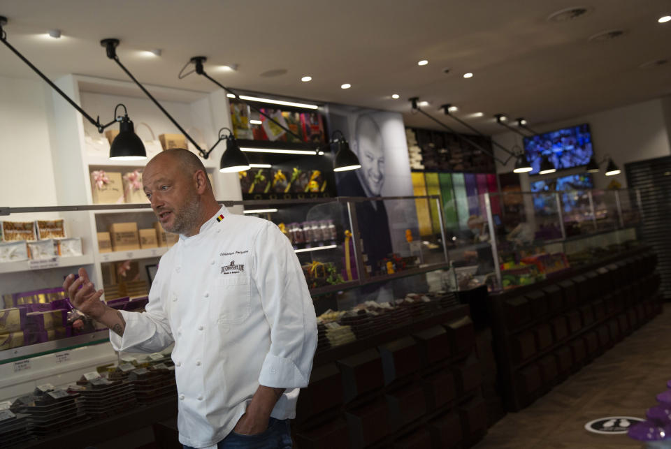 Belgian chocolatier Dominique Persoone speaks with a journalist at his Chocolate Line shop in Bruges, Belgium, Wednesday, Sept. 2, 2020. Tourism sector losses have piled up in the tens of billions of euros across the 27-nation European Union, and the continent's vaunted government support and social security system is under increasing strain to prop up the sector. (AP Photo/Virginia Mayo)