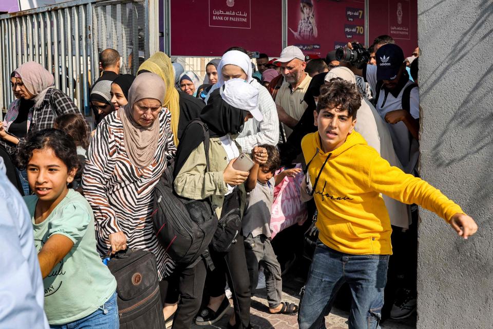 People walk through a gate to enter the Rafah border crossing to Egypt (AFP via Getty Images)