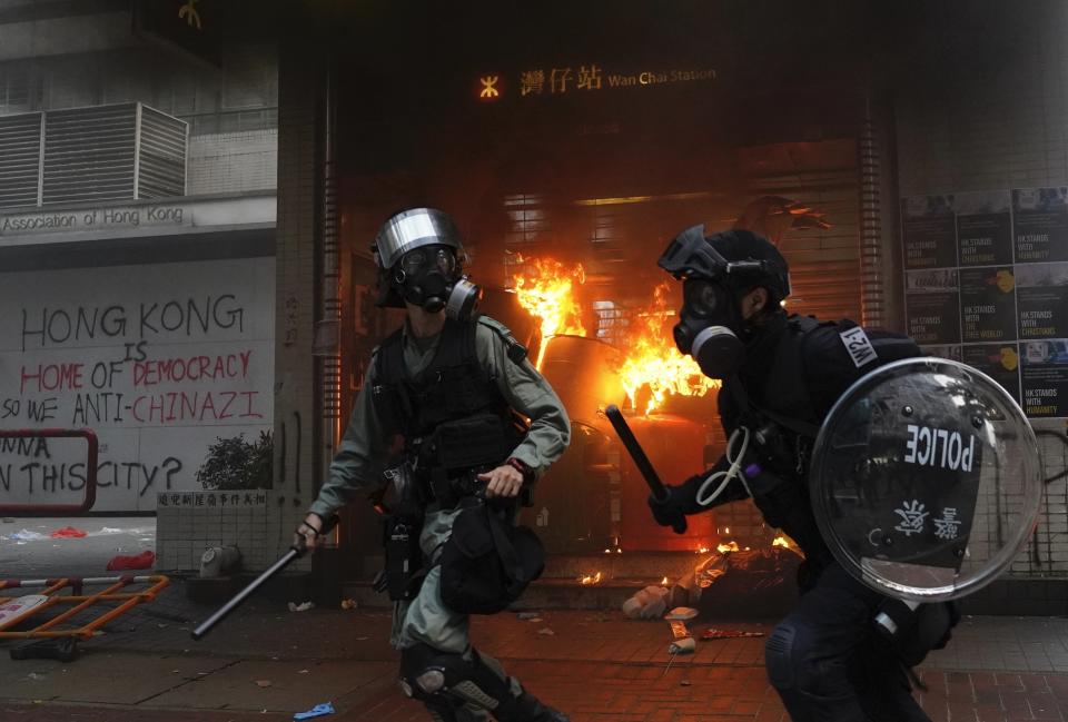 Riot police arrive after protestors vandalize in Hong Kong, Sunday, Sept. 29, 2019. Riot police fired tear gas Sunday after a large crowd of protesters at a Hong Kong shopping district ignored warnings to disperse in a second straight day of clashes, sparking fears of more violence ahead of China's National Day. (AP Photo/Vincent Yu)