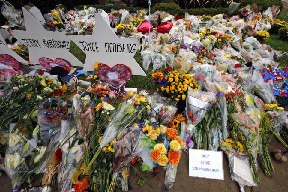 Flowers are placed Thursday, Nov. 1, 2018, at a makeshift memorial outside the Tree of Life Synagogue to the 11 people killed Oct 27, 2018 while worshipping in the Squirrel Hill neighborhood of Pittsburgh. (AP Photo/Gene J. Puskar)