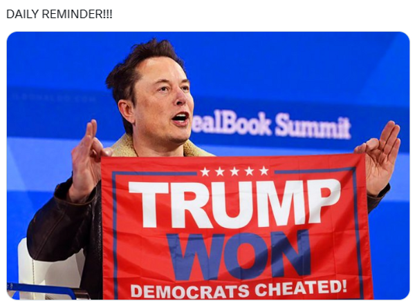 A white man holds a flag that says, "Trump won, Democrats cheated!" 