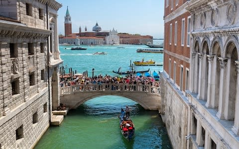 Tourists jostle for space on the Ponte della Paglia, Venice - Credit: Getty