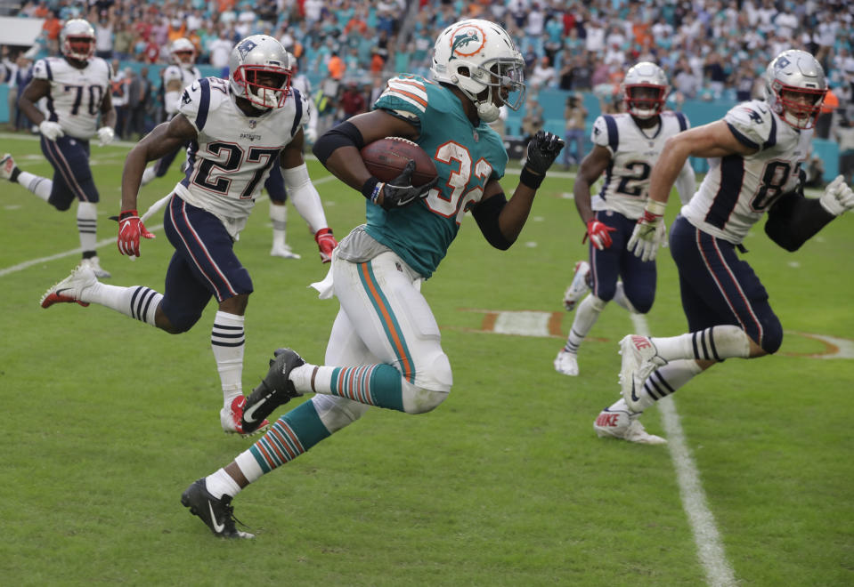 FILE - In this Dec. 9, 2018, file photo, Miami Dolphins running back Kenyan Drake (32) runs for a touchdown during the second half of an NFL football game against the New England Patriots, in Miami Gardens, Fla. The NFL revealed 70 of the 100 greatest plays in league history on Friday night with a TV special produced by NFL Films that has everything from spectacular offensive performances to defensive gems. In balloting conducted by The Associated Press, 68 media members on a nationwide panel voted for their top 100. Among those disclosed is the play some have dubbed “The Drake Escape.” (AP Photo/Lynne Sladky, File)