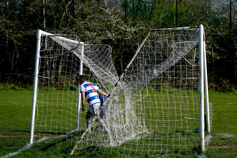 <p>A QPR supporters FC player pulls a goal net during the Chiswick and District Sunday League match at Brentford playing fields, Brentford. Picture date: Sunday April 4, 2021.</p>
