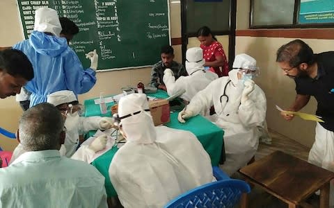  Medical personnel wearing protective suits check patients at the Medical College hospital in Kozhikode on May 21 - Credit:  AFP