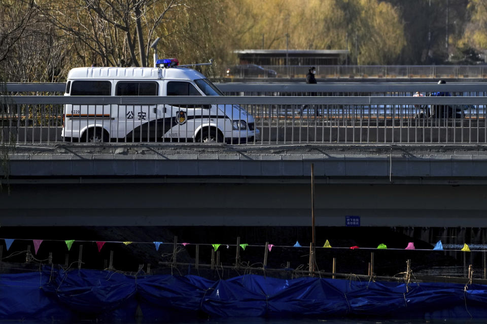 A police vehicle is parked on a bridge near the site of last weekend's protest in Beijing, Wednesday, Nov. 30, 2022. China's ruling Communist Party has vowed to "resolutely crack down on infiltration and sabotage activities by hostile forces," following the largest street demonstrations in decades staged by citizens fed up with strict anti-virus restrictions. (AP Photo/Andy Wong)