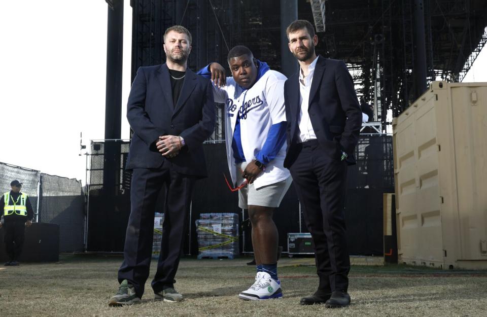 Three people pose backstage at Coachella