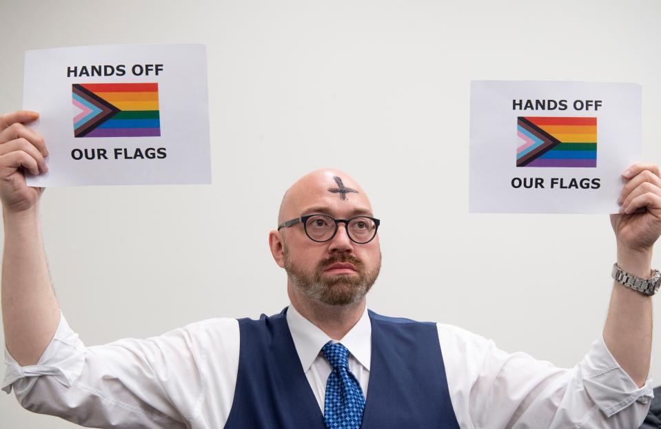 Brian Sullivan, Nashville co-chair for Tennessee Equality Project, holds up signs during a House committee meeting on Wednesday, Feb. 14, 2024 at the Cordell Hull State Office Building in Nashville.