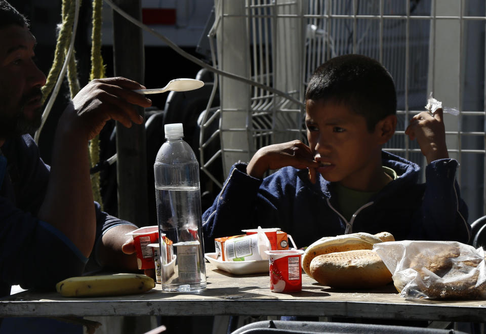 Central American migrants eat breakfast in a shelter at the Jesus Martinez stadium in Mexico City, Tuesday, Nov. 6, 2018. Humanitarian aid converged around the stadium in Mexico City where thousands of Central American migrants winding their way toward the United States were resting Tuesday after an arduous trek that has taken them through three countries in three weeks. (AP Photo/Marco Ugarte)