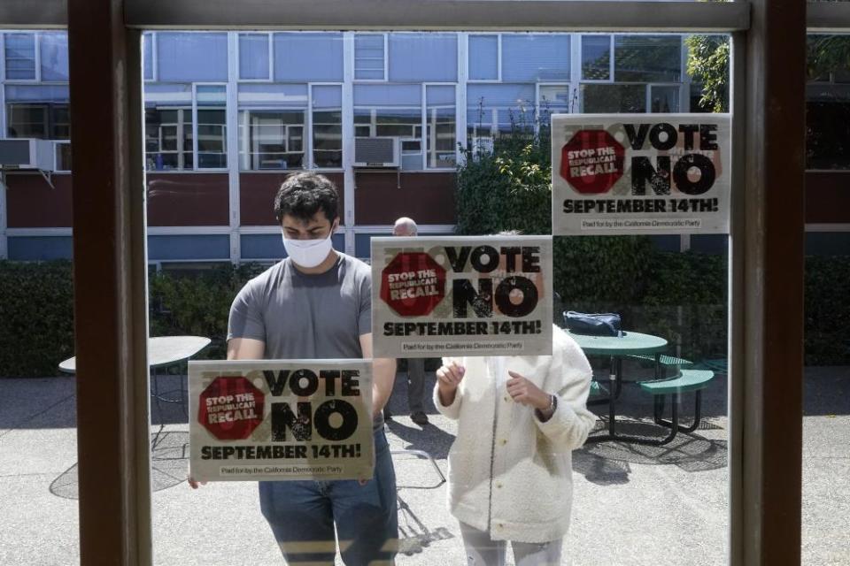 Volunteers put up signs in support of Gavin Newsom in San Francisco on 14 September.