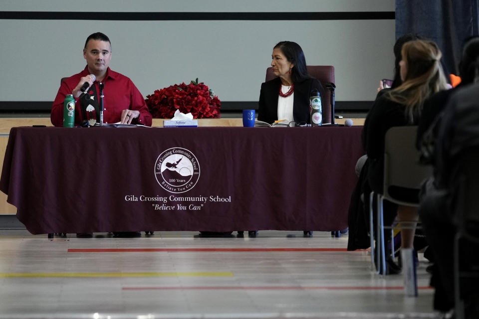 U.S. Interior Secretary Deb Haaland, right, listens as Assistant Secretary for Indian Affairs Bryan Newland speaks during a "Road to Healing" event, Friday, Jan. 20, 2023, at the Gila Crossing Community School in Laveen, Ariz. The "The Road to Healing," is a year-long tour across the country to provide Indigenous survivors of the federal Indian boarding school system and their descendants an opportunity to share their experiences. (AP Photo/Matt York)
